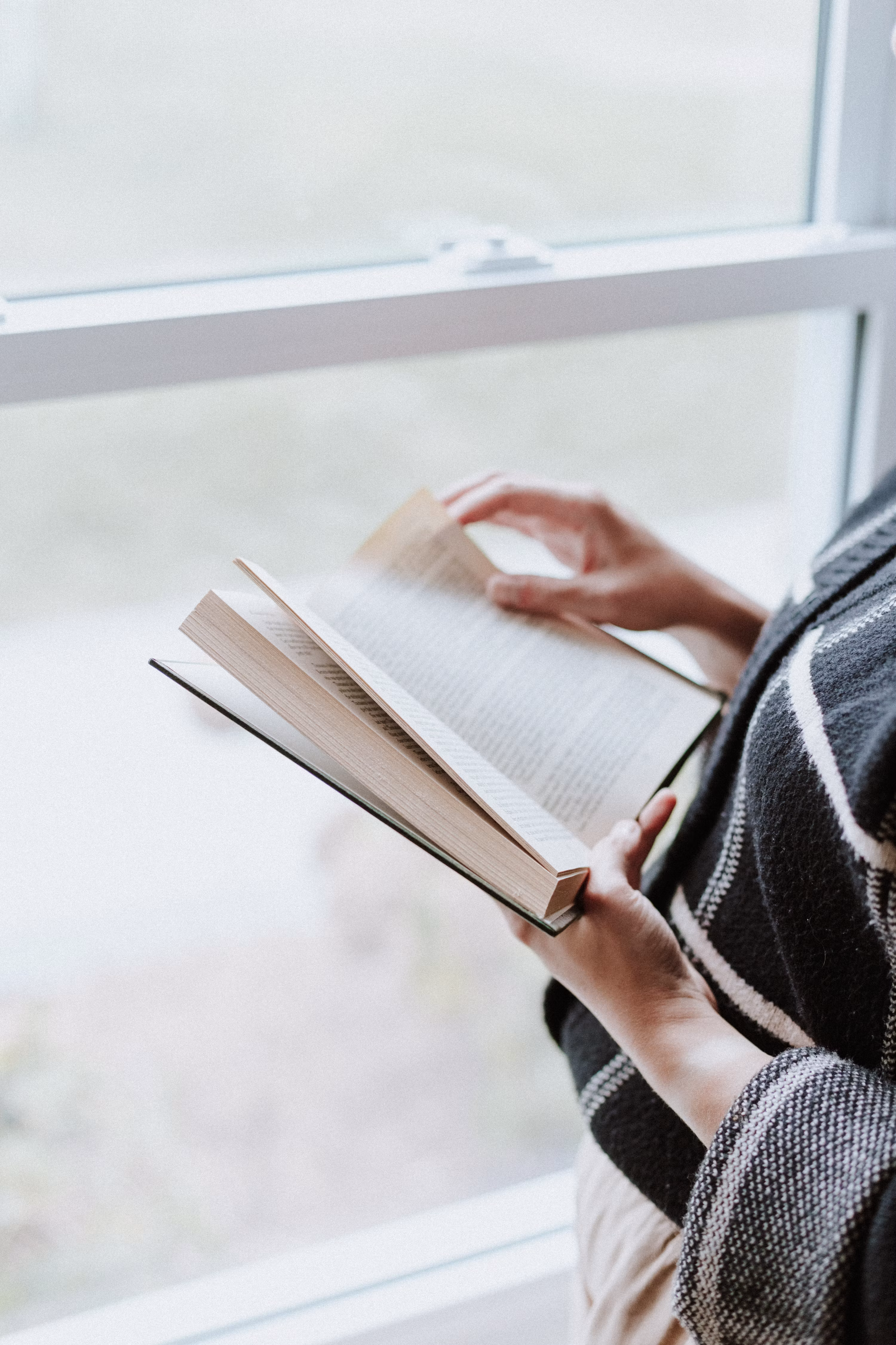 Reading book by window